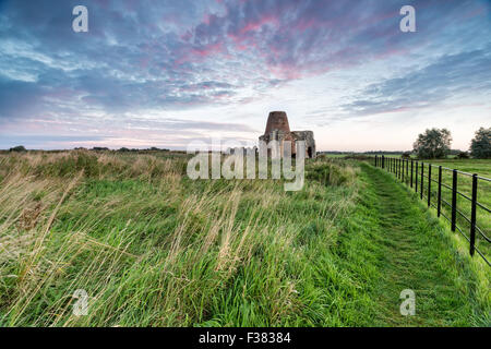 Sonnenaufgang am St Benet Abtei auf den Norfolk Broads, alles, was bleibt sind die Ruinen der das Torhaus und die Windmühle Stockfoto