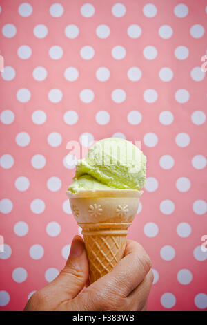 Frau Hand mit einem Eisportionierer in einem Kegel Stockfoto