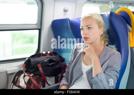 Blonde kaukasische Geschäftsfrau, Reisen mit dem Zug. Business Travel-Konzept. Stockfoto