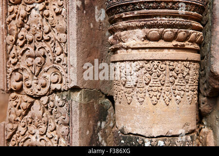 Fragment einer Wand mit verzierten Steinschnitzereien im alten Banteay Srei Tempel. Angkor Archäologischer Park, Provinz Siem Reap, Kambodscha. Stockfoto