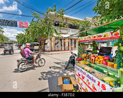 Mann auf dem Fahrrad durch einen Obst in der Alten Französischen Viertel von Siem Reap, Kambodscha abgewürgt. Stockfoto