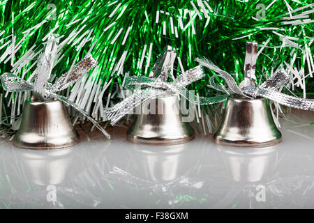 drei silberne Glocken auf dem Hintergrund der Grünen Kranz Stockfoto