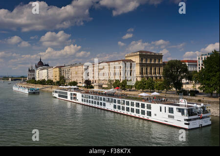 Ein Wikinger-Kreuzfahrt-Schiff vertäut am Ufer der Donau mit der ungarischen Akademie hinter in Budapest, Ungarn. Stockfoto