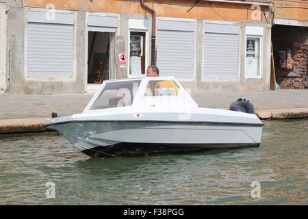 Ein Boot Geschwindigkeiten an einem Kanal in Venedig Italien Stockfoto