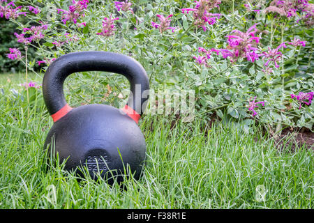 schweres Eisen Wettbewerb Kettlebell auf dem grünen Rasen in einem Hinterhof - outdoor-Fitness-Konzept Stockfoto