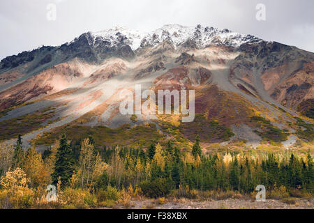 Die Sonne lugt durch eine teilweise bewölkter Himmel, die Alaska Range zu beleuchten Stockfoto