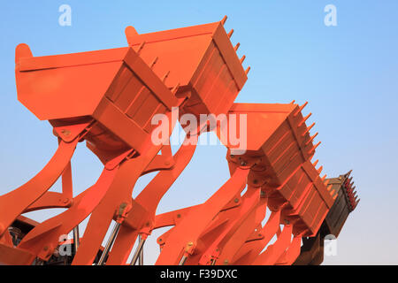 Teil der modernen gelben Bagger Maschinen, die Eimer/Schaufeln gegen den blauen Himmel in einer Baustelle angehoben. Stockfoto