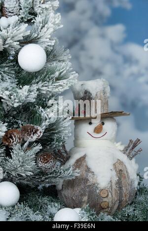 Schneemann neben Weihnachtsbaum Stockfoto