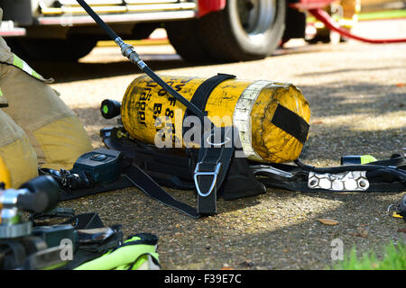 Feuerwehrmann bereitet sein Atemgerät, am Tatort eines Feuers. Stockfoto