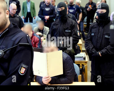 Offiziere des Special Operations Befehl (SEK) der deutschen staatlichen Polizei stehen hinten und vorne die Beklagten an das Landgericht in Schleswig, Deutschland, 2. Oktober 2015. Der Prozess gegen zwölf mutmaßliche Mitglieder eines östlichen europäischen kriminellen Bande begann unter strengen Sicherheitsvorkehrungen Masseinheiten. Die Männer sind mehrere Raubüberfälle vorgeworfen. Nach der Prosecuters beraubt sie ein Pfandhaus in Kiel und ein Juwelier in Düsseldorf unter anderen Verbrechen in den letzten Jahren. Foto: Carsten Rehder/Dpa (Achtung: die Gesichter der Angeklagten wurden verpixelt aufgrund von Problemen der Persönlichkeitsrechte) Stockfoto