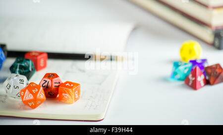 Bunte Würfel mit Bleistiften, Notebook und Büchern im Hintergrund Stockfoto