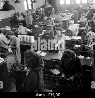 historische, weibliche Arbeitnehmer, die im Lager Druck von Etiketten, der 1950er Jahre betreut von männlichen Vorarbeiter oder Manager. Stockfoto