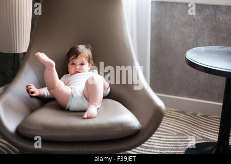 Sechs Monate altes Baby Mädchen entspannend in einem Drehstuhl. Stockfoto