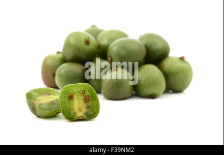 Eine Kiwi Beere geschnitten offen vor Haufen von Beeren, isoliert auf weißem Hintergrund Stockfoto