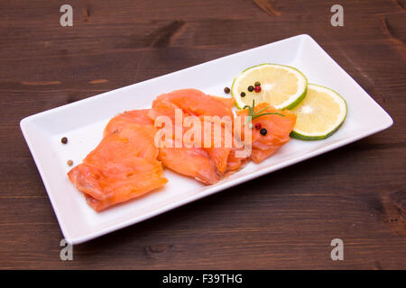 Geräucherter Lachs auf Tablett auf Holztisch Stockfoto