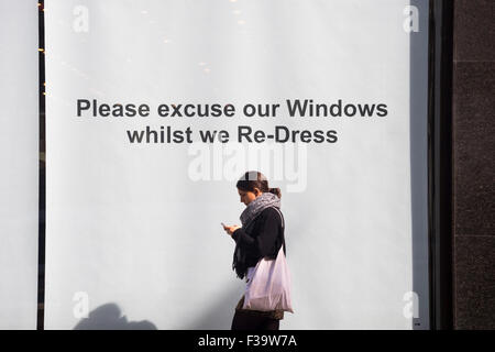 "Bitte entschuldigen Sie unsere Fenster, während wir uns neu kleiden" anmelden, Schaufenster auf der Londoner Regent Street. Stockfoto