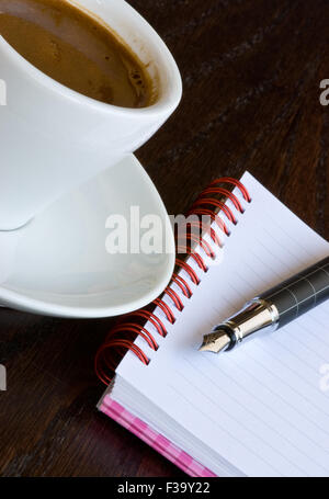 Black Coffee und Spiral-Notizbuch mit einem Kugelschreiber. Business-Konzept Stockfoto