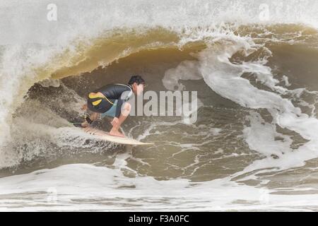 Eine Surfer reitet eine Welle an der Torheit Auswaschung im Laufe der Hurrikan Joaquin vor der Küste bringen hohe Brandung und Rip-Gezeiten zu den Stränden entlang der Küste South Carolinas 2. Oktober 2015 in Folly Beach, SC. Joaquin wird voraussichtlich die Carolinas zu vermeiden, sondern hat bereits hohe Brandung und Überschwemmungen verursacht. Stockfoto