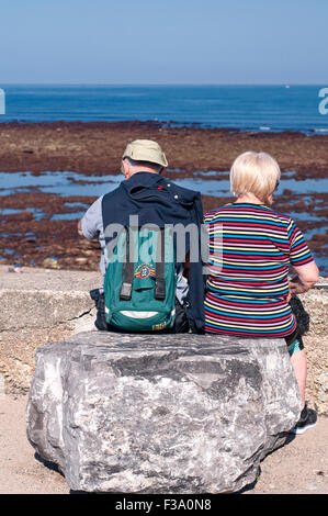 Älteres paar entspannende an einem sonnigen Tag mit Blick auf das Meer. Stockfoto