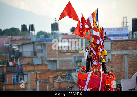 Kathmandu, Nepal. 2. Oktober 2015. Priester eine heilige Kokosnuss (Frucht des Glaubens) in Richtung der Masse von der Spitze des Rato Macchendranath Wagen in Lagankhel zu werfen. Nach alten glauben, wer den geworfenen Heilige Kokos-Frucht fängt, es mit einem Baby Sohn gesegnet werden und jährlich Prosper Leben voraus. Der Wagen zieht Festival von Rato Macchendranath nimmt nach der Renovierung, die von Erdbeben betroffen war. © Narayan Maharjan/Pacific Press/Alamy Live-Nachrichten Stockfoto