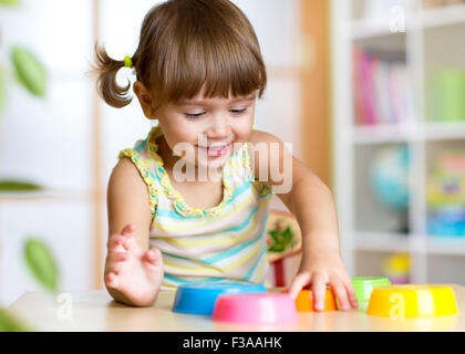 junge Mädchen spielen mit Spielzeug drinnen Stockfoto