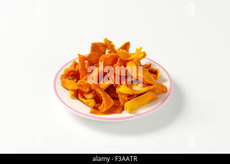 Teller mit getrocknete Mango Scheiben auf weißem Hintergrund Stockfoto