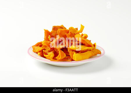 Teller mit getrocknete Mango Scheiben auf weißem Hintergrund Stockfoto