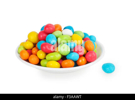 bunte Bonbons in weiße Untertasse isoliert auf weißem Hintergrund Stockfoto
