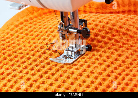 Nähmaschine Arbeitsteil mit orange Tuch Stockfoto