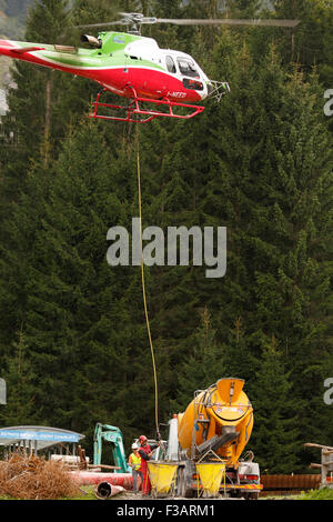 Falcade, Belluno, Italien - 21. August 2015: Transporthubschrauber liefert Material für eine Baustelle in den Bergen Stockfoto