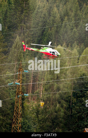 Falcade, Belluno, Italien - 21. August 2015: Transporthubschrauber liefert Material für eine Baustelle in den Bergen Stockfoto