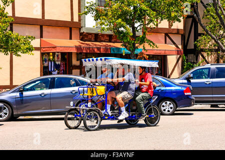 Touristen, die auf eine Quadcycle in der dänischen Stil Dorf Solvang in Santa Ynez Valley in Kalifornien herumfahren Stockfoto