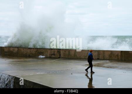 Chicago, Illinois, USA. 3. Oktober 2015.  Ein kleiner Junge schaut zu, wie eine große Welle in der Ufermauer am Montrose Strand stürzt. Mehrere Tage starke Nordostwinde getrieben haben "Wellenlinien" bis zu 15 Fuß hoch auf Chicagos Ufer. Bildnachweis: Todd Bannor/Alamy Live-Nachrichten Stockfoto