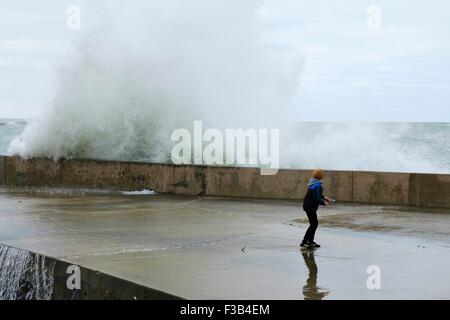 Chicago, Illinois, USA. 3. Oktober 2015.  Ein kleiner Junge schaut zu, wie eine große Welle in der Ufermauer am Montrose Strand stürzt. Mehrere Tage starke Nordostwinde getrieben haben "Wellenlinien" bis zu 15 Fuß hoch auf Chicagos Ufer. Bildnachweis: Todd Bannor/Alamy Live-Nachrichten Stockfoto