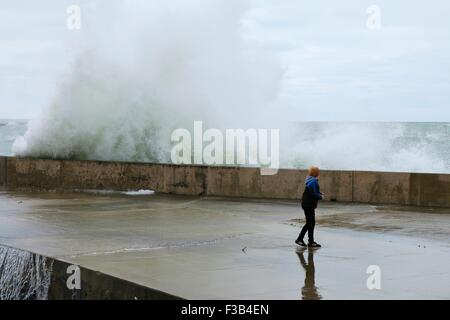 Chicago, Illinois, USA. 3. Oktober 2015.  Ein kleiner Junge schaut zu, wie eine große Welle in der Ufermauer am Montrose Strand stürzt. Mehrere Tage starke Nordostwinde getrieben haben "Wellenlinien" bis zu 15 Fuß hoch auf Chicagos Ufer. Bildnachweis: Todd Bannor/Alamy Live-Nachrichten Stockfoto