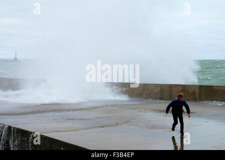 Chicago, Illinois, USA. 3. Oktober 2015.  Ein kleiner Junge weicht eine Welle auf der Ufermauer in Montrose Beach. Mehrere Tage starke Nordostwinde getrieben haben "Wellenlinien" bis zu 15 Fuß hoch auf Chicagos Ufer. Bildnachweis: Todd Bannor/Alamy Live-Nachrichten Stockfoto