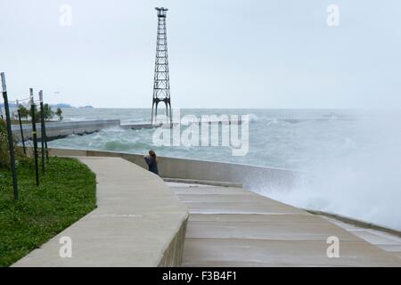 Chicago, Illinois, USA. 3. Oktober 2015.  Eine junge Frau weicht Wellen während der Einnahme von nassen Joggen entlang der Ufermauer am Montrose Strand heute. Mehrere Tage starke Nordostwinde haben die Wellen so hoch wie 15 Fuß auf Chicagos Ufer getrieben. Bildnachweis: Todd Bannor/Alamy Live-Nachrichten Stockfoto