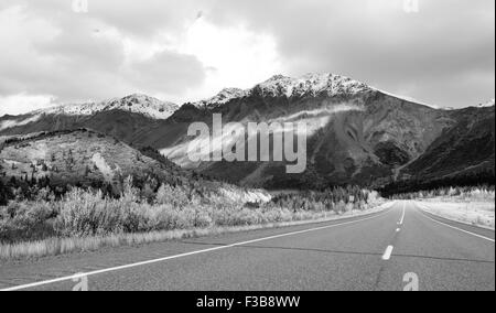 Die Sonne lugt durch eine teilweise bewölkter Himmel, die Alaska Range zu beleuchten Stockfoto