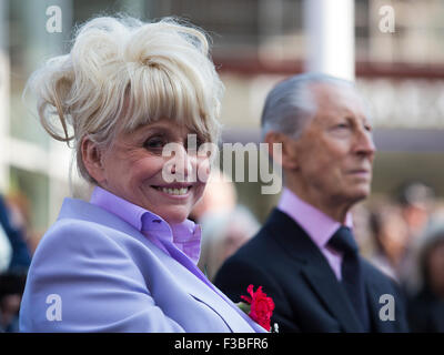 Stratford, London, UK. 10.04.2015. Schauspielerin Barbara Windsor sitzt neben Schauspieler Murray Melvin. Enthüllung der Joan Littlewood Skulptur von Philip Jackson in Theaterplatz außerhalb Theatre Royal Stratford East. Stockfoto