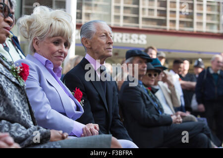 Stratford, London, UK. 10.04.2015. Schauspielerin Barbara Windsor sitzt neben Schauspieler Murray Melvin. Enthüllung der Joan Littlewood Skulptur von Philip Jackson in Theaterplatz außerhalb Theatre Royal Stratford East. Stockfoto