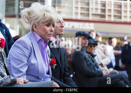 Stratford, London, UK. 10.04.2015. Schauspielerin Barbara Windsor sitzt neben Schauspieler Murray Melvin. Enthüllung der Joan Littlewood Skulptur von Philip Jackson in Theaterplatz außerhalb Theatre Royal Stratford East. Stockfoto