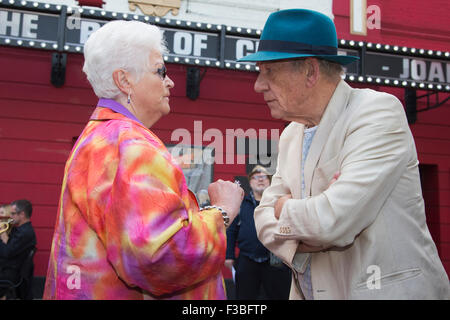 Stratford, London, UK. 10.04.2015. Schauspieler Pam St. Clement und Sir Ian McKellen im Gespräch. Enthüllung der Joan Littlewood Skulptur von Philip Jackson in Theaterplatz außerhalb Theatre Royal Stratford East. Stockfoto