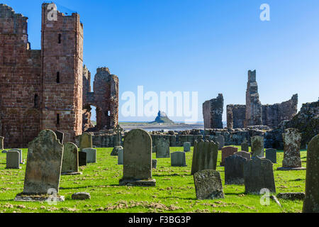 Die Ruinen von Lindisfarne Priory mit Lindisfarne Castle in die Ferne, Holy Island, Northumberland, England, UK Stockfoto