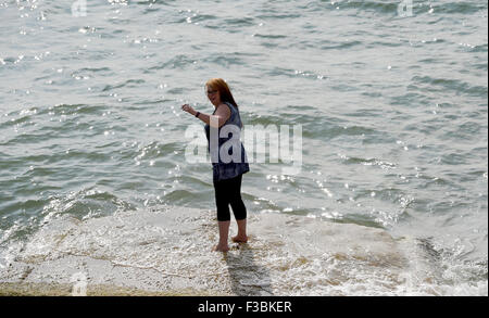 Brighton UK Sonntag, 4. Oktober 2015 - eine junge Frau genießt eine Paddel am Rande Meer, wie sie den schönen Spätsommer-Sonnenschein auf Brighton Seafront heute genießt. Stockfoto