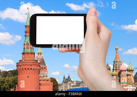 Konzept - Hand hält, das Smartphone mit Bildschirm und roten Türme des Moskauer Kremls auf Hintergrund ausschneiden zu reisen Stockfoto