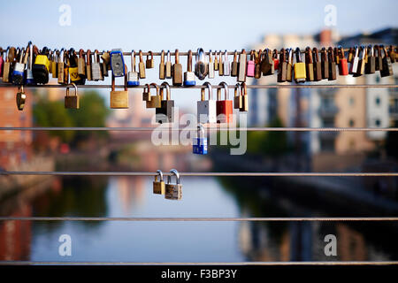 Vorhängeschlösser, die an Drahtgeländern der Centenary Bridge über den Fluss Aire im Calls-Gebiet von Leeds, Yorkshire, befestigt sind. VEREINIGTES KÖNIGREICH Stockfoto