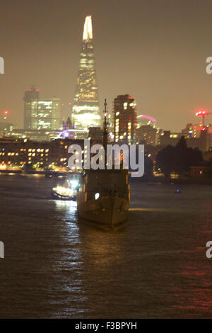 London, UK.  4. Oktober 2015. Brasilianische Marine Schulschiff "Brasil" U27 Köpfe ihren Weg von ihrem Liegeplatz an der Tower Bridge in der Dunkelheit und Köpfe stromabwärts zu ihrem Herangehen an die Docklands. Antenne-Stil gedreht genommen zeigen die Scherbe und Tower Bridge im Hintergrund, zusammen mit der Docklands. Bildnachweis: Glenn Sontag / Alamy Live News Stockfoto