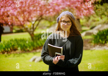 Junger Student stehend mit Bücher in der hand Stockfoto