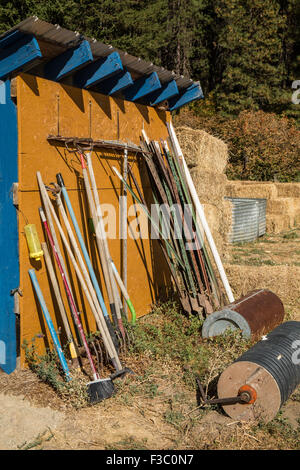 Geräteschuppen mit einer Vielzahl von Gartengeräte wie Rechen, Besen, Stangen und Rollen, in Leavenworth, Washington, USA Stockfoto