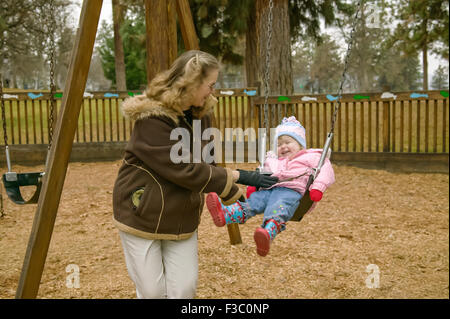 Frau treibt zwei Jahres altes Mädchen in einem Schwung in The Dalles, Oregon, USA Stockfoto